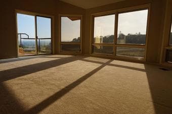 Large room with beautiful bay windows looking out into the sun 2